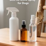 Three spray bottles on a wooden table beside a chewed table leg, with the title Best No Chew Spray for Dogs