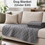 Grey quilted waterproof dog blanket draped over the seat cushions of a beige sofa